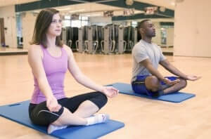 15407-a-man-and-woman-practicing-yoga-in-a-fitness-center-pv